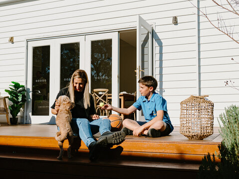Mother and son spending time outside in the wooden deck.