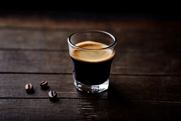 Coffee in glass cup on dark background. Close up. Copy space.