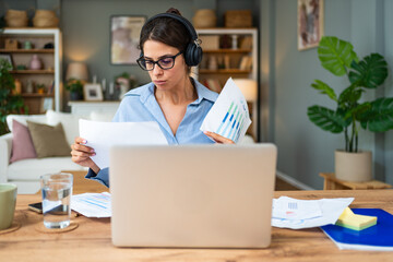 Smiling young woman working at home. Successful professional occupation female work on laptop...