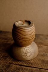 Conceptual handmade wooden candle with beeswax on a stand. A candle with a modern design. Close-up