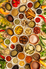Assorted spices and herbs on a beige background, offering rich scents and vibrant colors, ideal for adding depth and warmth to any culinary creation