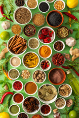 Brightly colored spices and herbs arranged on a delicate green background, highlighting their freshness and fragrance for a lively, natural look