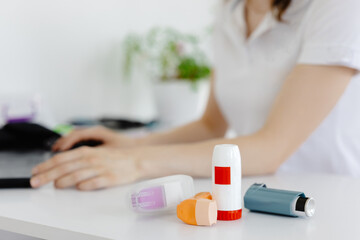 Doctor writes at laptop medical prescription for asthma inhaler to asthmatic patient during medical consultation and examination in clinic