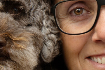 Close-up portrait of a woman owner with his poodle dog with similar eyes