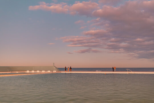 The Newcastle Ocean Baths at dusk with pink and purple fairy floss sky