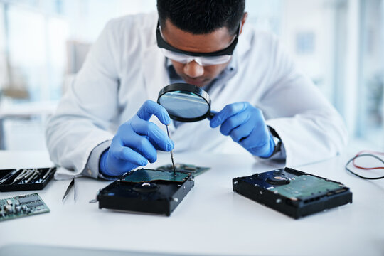 Engineering, hardware and man in lab with magnifying glass in motherboard maintenance, repair or technology. IT, research and electronic technician with circuit board, tools and computer innovation.