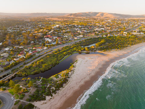 Aerial view of coastal wetlands between a sandy beach and a seaside town