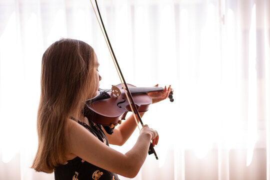 child deep in concentration while playing violin