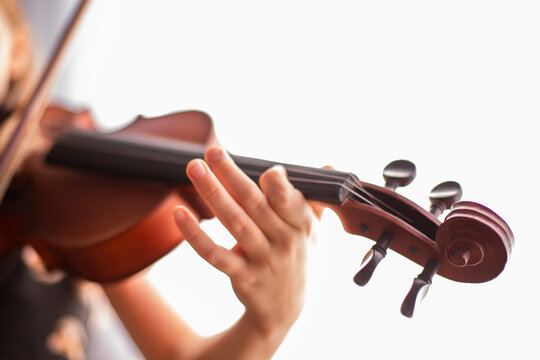 close up of violin scroll and pegs while a child is playing