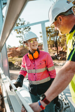 A contractor teaching a young apprentice how to use the level on worksite