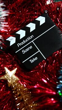 vertical footage of clapper board red tinsel background
