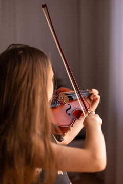 child with long hair preparing to play the violin