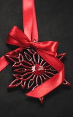 Elegant red snowflake tree ornament with satin bow, festive Christmas decoration symbolizing holiday cheer in vibrant red hue