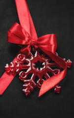 Elegant red snowflake tree ornament with satin bow, festive Christmas decoration symbolizing holiday cheer in vibrant red hue