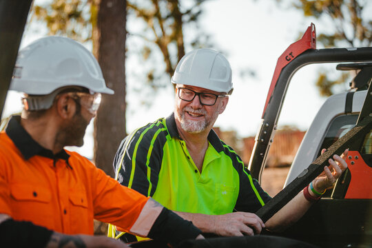 Two builders standing next to the ute on worksite
