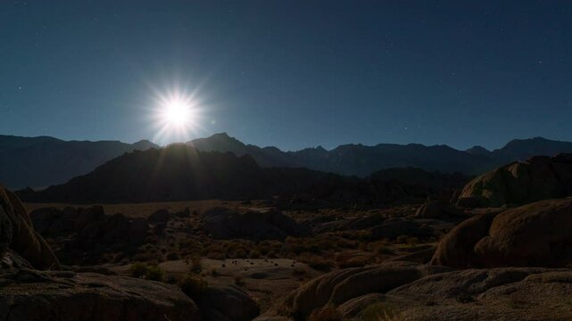 Timelapse transition from moonset to sunrise over Sierra Nevada Mountains in California, USA