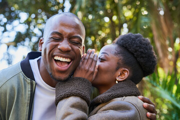 Joyful Couple Sharing Secrets Outdoors in a Sunlit Park