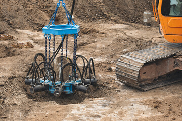 Excavator using a hydraulic pile cropper to cut off top of concrete pile