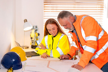 Professionals collaborate on construction plans in a bright office during the day