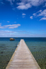 Obraz premium Empty wooden pier for swimming and hardening in the sea, Copenhagen, Denmark, sunny day, blue sky copy space