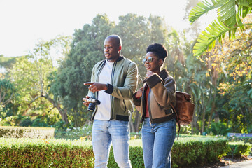 Couple Enjoying a Leisurely Walk in a Lush Green Park on a Sunny Day