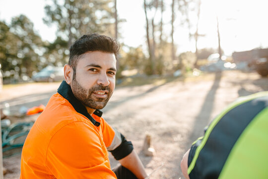 Closeup of a construction worker sitting on the ground of the construction site.