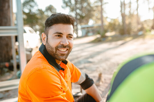 Closeup of a construction worker sitting on the ground of the construction site.