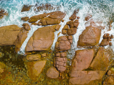 Aerial view of waves washing into chutes in a rocky coastline