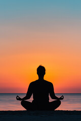 A serene silhouette of a person meditating at sunset by the ocean, embodying tranquility and mindfulness against a vibrant horizon.