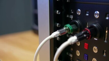 A close-up view of audio cables connecting to a technology device, emphasizing electronic integration and sound settings.