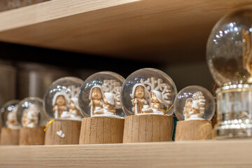 Christmas snow globes stand in a row on store shelves