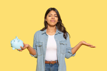Young woman considering savings options with a piggy bank against a bright yellow background