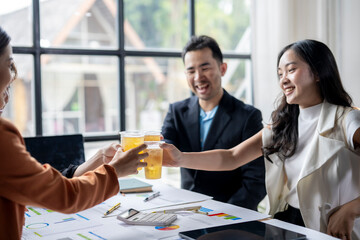 Business team celebrating success with drinks in the office