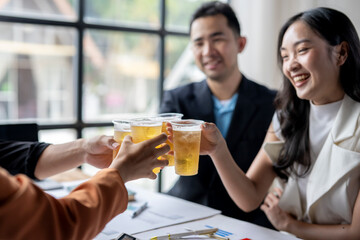 Business people toasting with beer in office after successful meeting