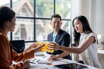 Business team celebrating success with drinks in office meeting