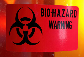 A red bio-hazard warning sticker on a glass surface