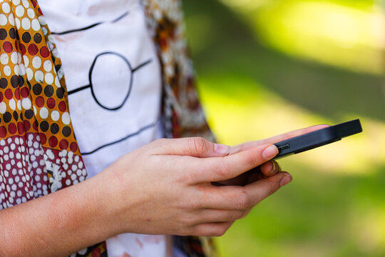 Mobile phone device in hands of aboriginal teen girl