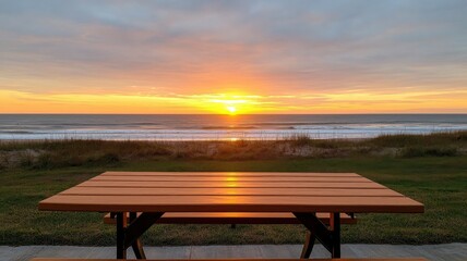 A wooden table overlooking a breathtaking sunset by the beach.