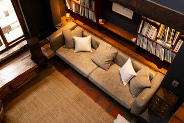 Cozy living room with comfortable sofa and bookshelves, warm and inviting atmosphere, at home