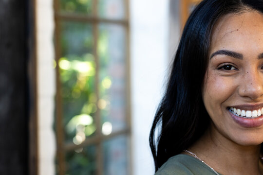 Standing near window, woman smiling while celebrating Thanksgiving at home, copy space