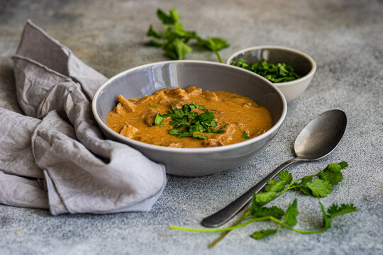 Delicious beef stroganoff with fresh coriander garnish in bowl