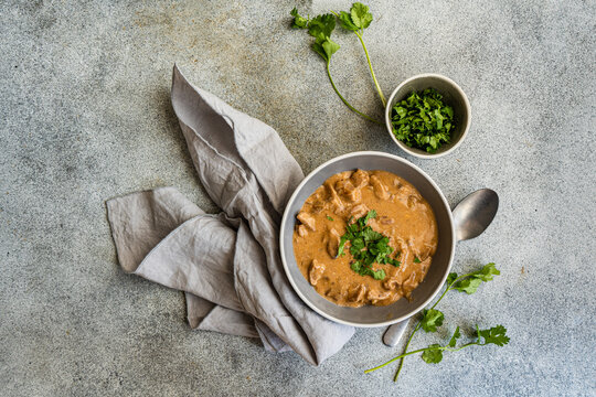 Delicious beef stroganoff in creamy sauce garnished with coriander