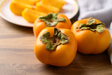 Ripe persimmon fruit on wooden background, Autumn fruit