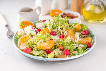 Salad bowl with lettuce, tangerines, nuts and cranberry