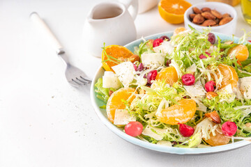 Salad bowl with lettuce, tangerines, nuts and cranberry