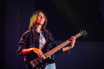 Female musician performing on stage with bass guitar