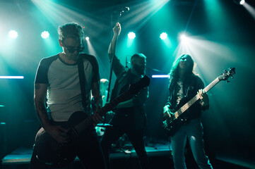 Rock band performing live on stage with energetic guitarist