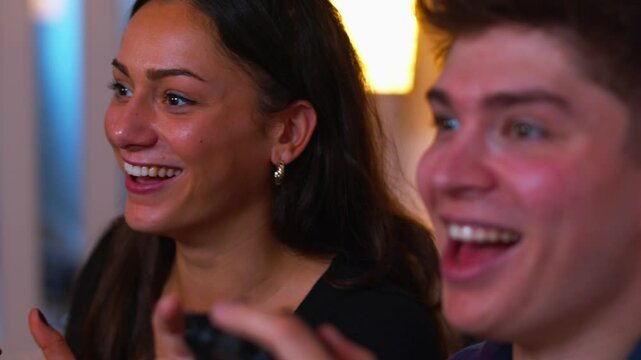 Cute couple gaming intensely celebrates and smiles at each other