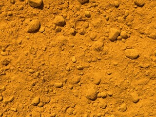 A close-up view of vibrant yellow-orange powder, showcasing a textured surface that suggests fine...