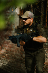 Fototapeta premium Soldier aiming assault rifle while patrolling abandoned building,